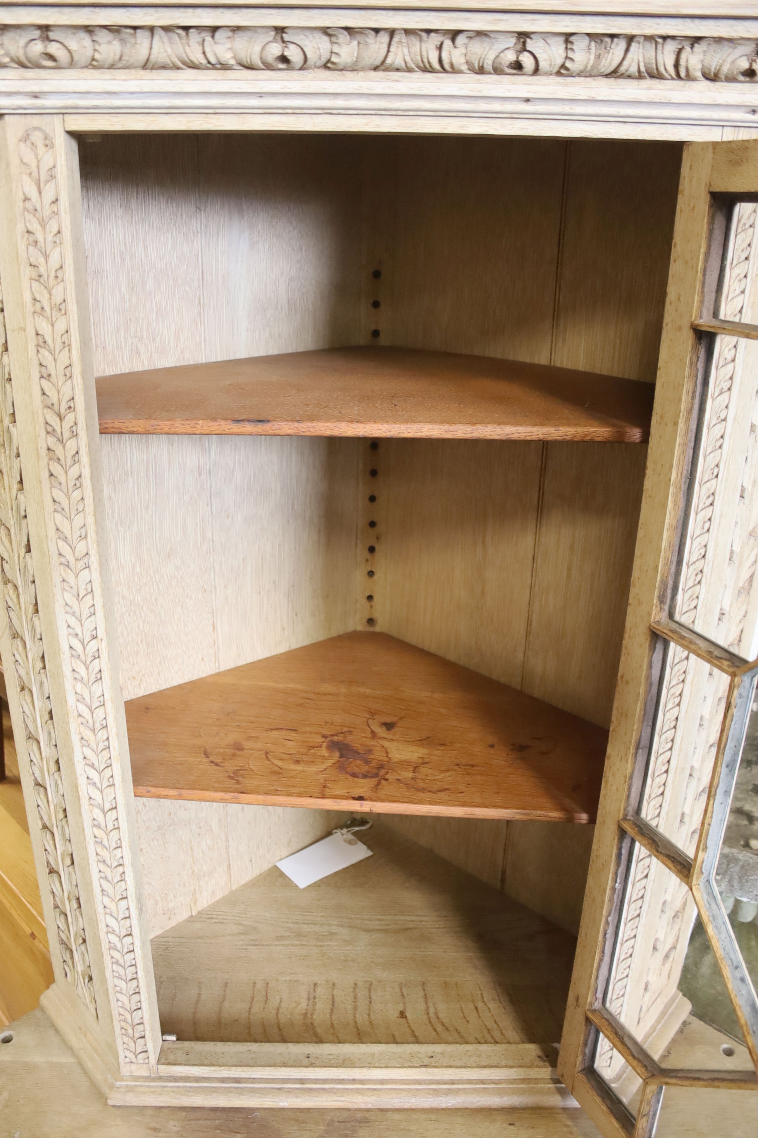 A Flemish bleached oak corner cabinet, width 98cm, depth 70cm, height 190cm